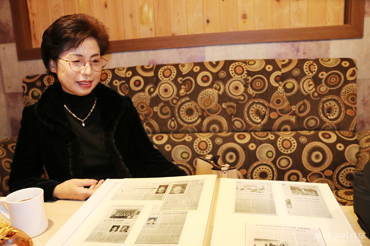 김두례 위원장이 봉사 활동을 소개한 언론 기사 스크랩을 펼쳐 보이며 지난 시절을 회상하고 있다.